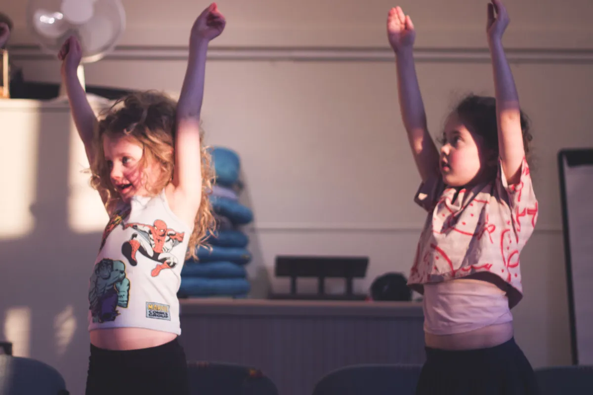 Dansende meisjes met armen omhoog
